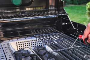 Cesta con carbón y parrilla de gas al lado en una barbacoa Hibrida de la marca CharBroil